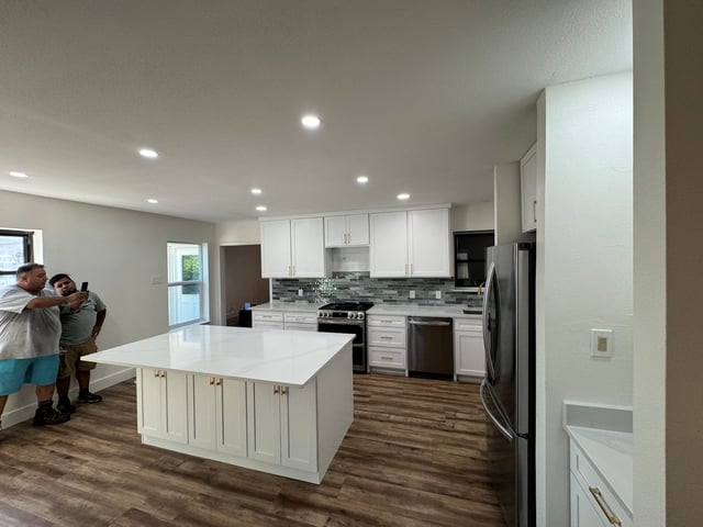 Open-concept kitchen remodel with quartz island and stainless appliances