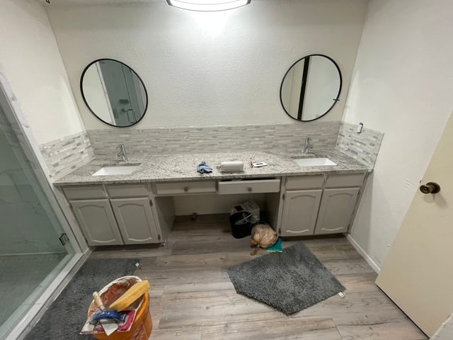 Double vanity bathroom remodel with granite top and mosaic tile backsplash